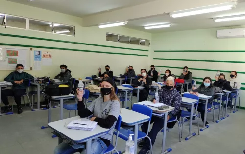 Estudantes em sala de aula com a garrafinha d'água do projeto de sustentabilidade na escola