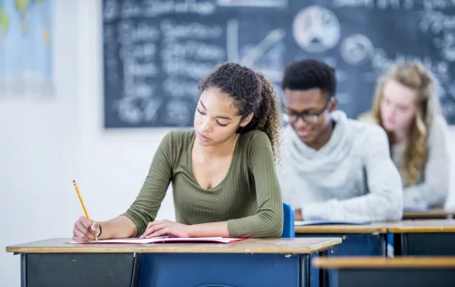 Estudantes em sala de aula fazendo prova de Olimpíada Científica