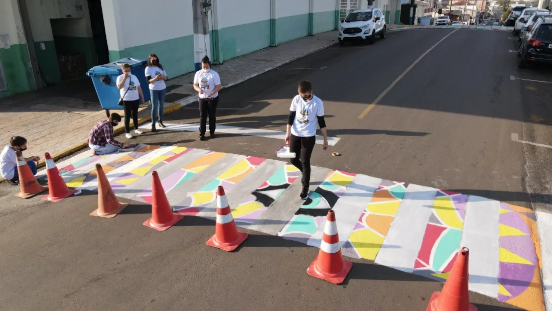 Professoras e alunos pintando faixa em Projeto de 'Arte na Rua' da EEB Paulo Blasi, em Campos Novos 