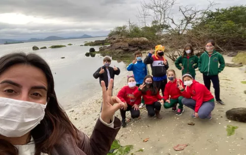 Alunos da EEB Engenheiro Annes Gualberto, de São Francisco do Sul, realizando ação de limpeza na praia em projeto de educação ambiental