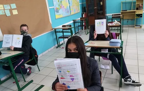 Estudantes em sala de aula na EEB Araújo Figueiredo, de Urubici, segurando caderno e aprendendo matemática no projeto escolar "Malala"