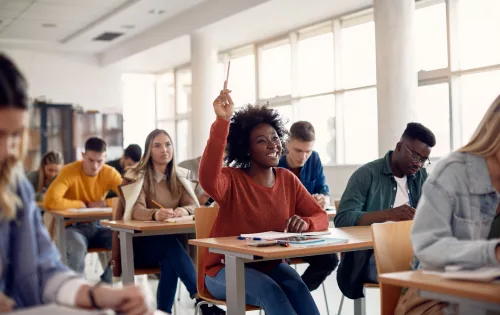 Aluna levantando a mão em sala de aula