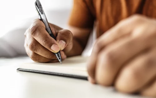 Menino escrevendo em um caderno