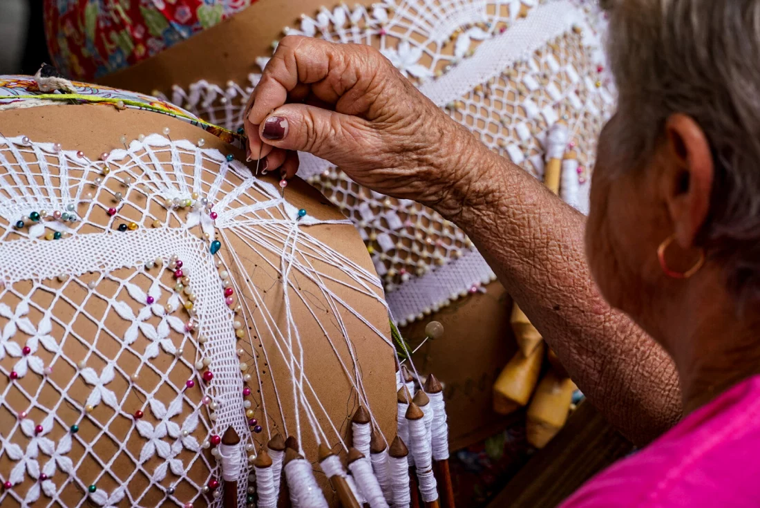 mulher idosa fazendo renda de bilro, atividade tradicional trazida pelos imigrantes açorianos 