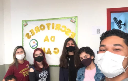 Estudantes do Ensino Médio da Escola de Educação Básica (EEB) Professora Gracinda Augusta Machado, de Imbituba, no Litoral Sul do Estado, reunidos em frente a um cartaz do projeto de escrita "Escritores da GAM"