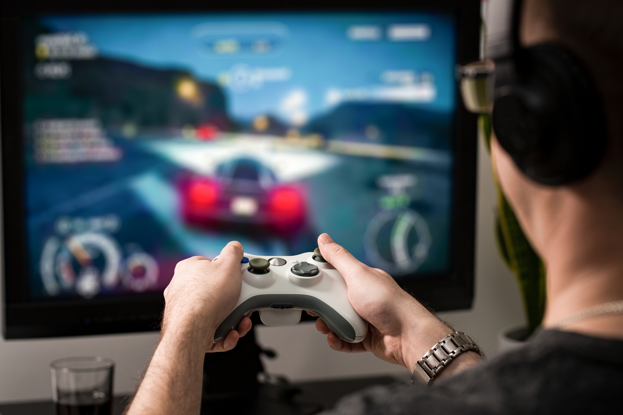 Imagem mostra um garoto segurando um controle de video-game jogando um jogo online
