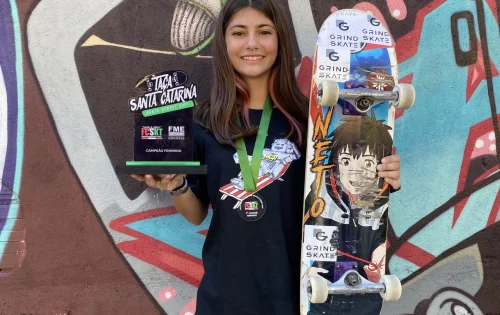 Estudante Giovana Gabriela Roeder, segurando skate e taça do campeonato estadual de skate